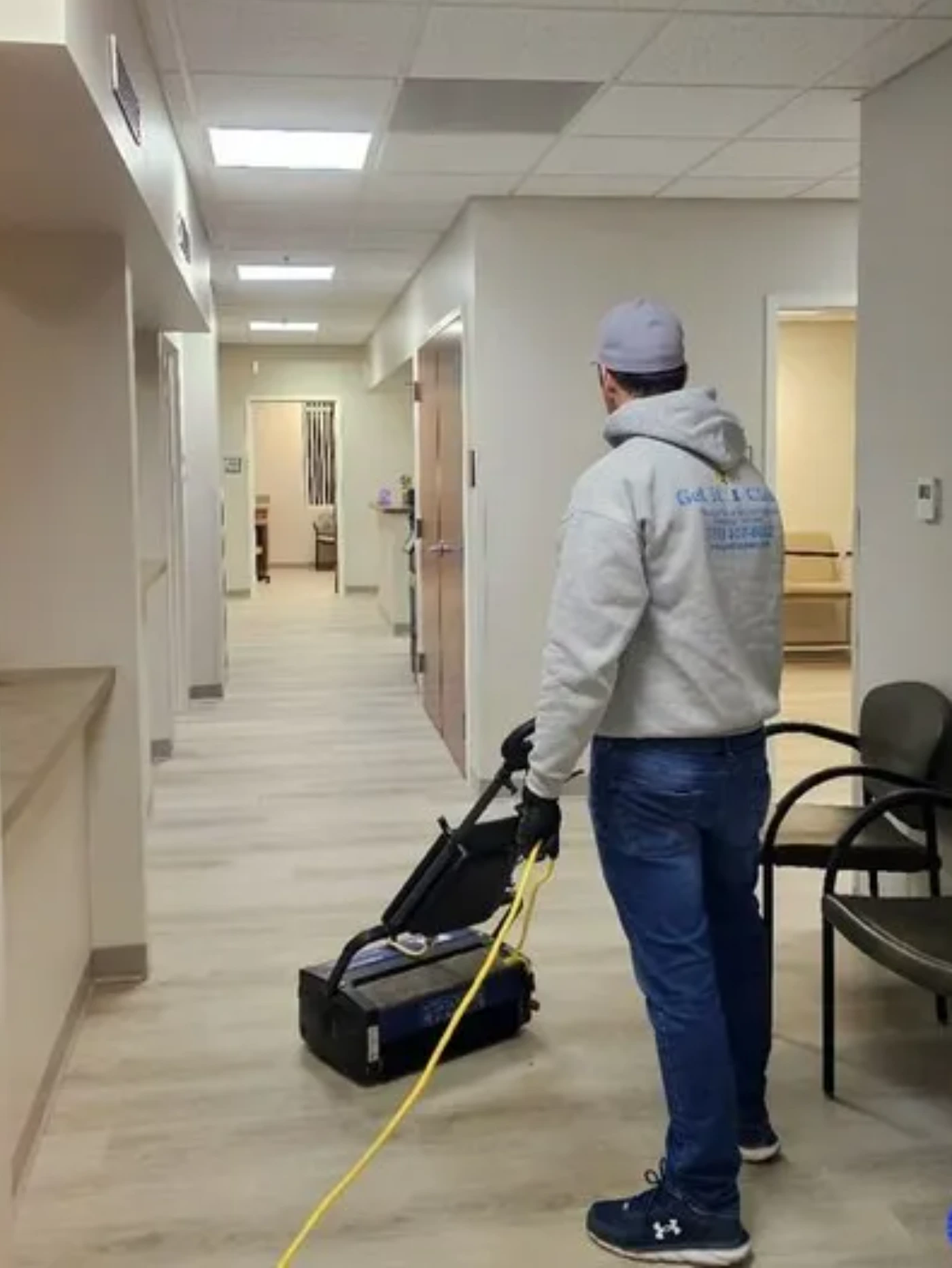 Medical and commercial floor cleaning specialists Get it Clean Services technician buffing floors in a medical facility hallway